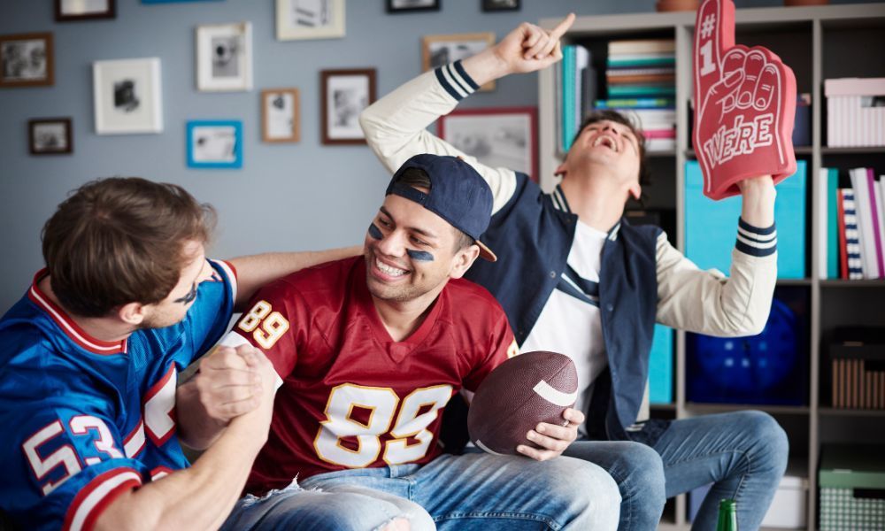 Drei junge Männer schauen zu Hause Football