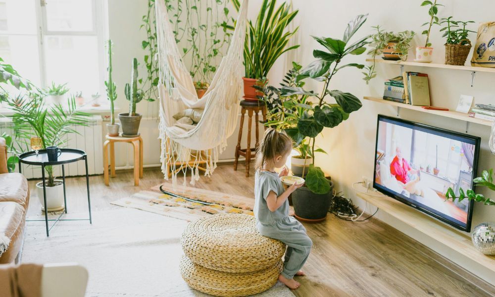 Mädchen sitzt alleine mit Müsli vor TV 